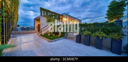 Terrasse sur le toit exclusive avec une végétation luxuriante, offrant une expérience de vie en plein air luxueuse et une vue imprenable. Banque D'Images