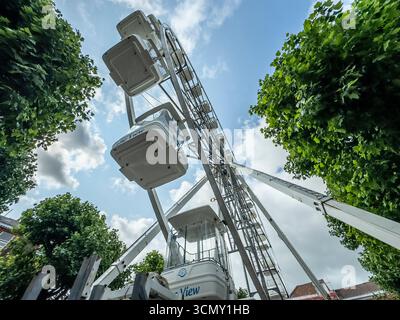 L'attraction View Ferris Wheel à York, Yorkshire, Angleterre, s'élevant au-dessus des arbres contre un ciel bleu avec des nuages. Banque D'Images
