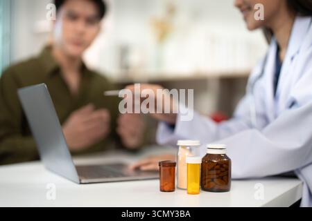 Revue des médicaments. Diététiste discutant des options thérapeutiques avec un patient de sexe masculin. Banque D'Images