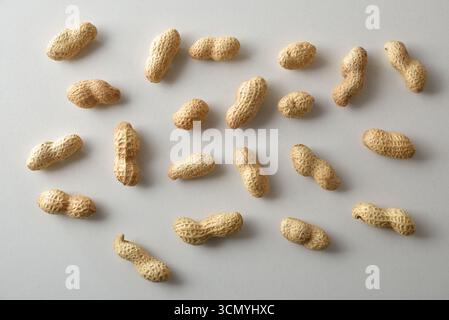 Détail de plusieurs cacahuètes montrant diverses formes et textures sur une table en bois. Vue de dessus. Banque D'Images