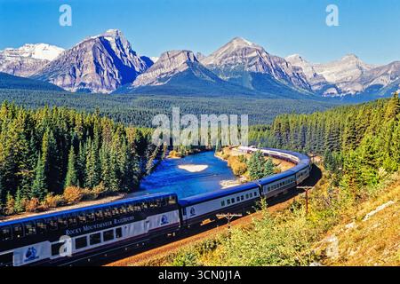 Chemin de fer canadien pacifique conduite dans une vallée de montagne par une rivière dans les rocheuses canadiennes Banque D'Images