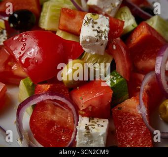 Salade grecque saine avec légumes frais olives oignon rouge concombre tomate et cubes de fromage feta dans un bol. Conçu pour la photographie de stock de nourriture. Banque D'Images