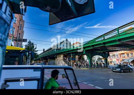 Vue urbaine plus large du U-Bahn Eberswalder Straße avec cycliste flou, feux de circulation et vie dynamique de la rue en face de la gare. Banque D'Images