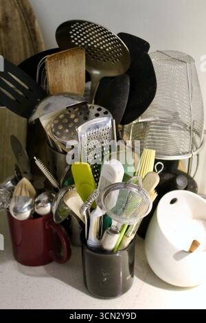 Ustensiles de cuisine et sel de mer sur un banc à côté du poêle Banque D'Images