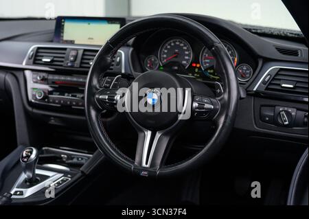 Derby, Royaume-Uni - 19 septembre 2025 : volant BMW, arborant le logo emblématique de la cocarde BMW, boutons multifonctions intégrés Banque D'Images