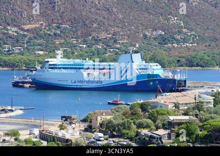 La Méridionale Ferry amarré dans le port serein avec Hillside Town en arrière-plan. Porto-Vecchio, Corse, France Banque D'Images