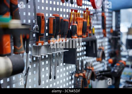 Une collection de divers outils est accrochée sur un mur organisé Banque D'Images