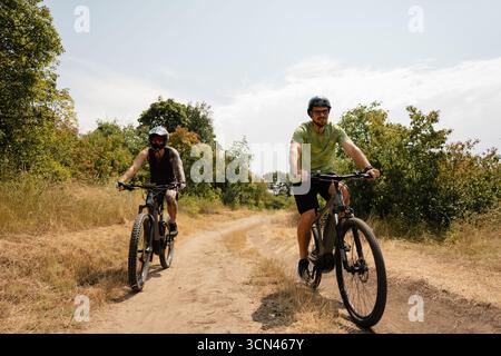 Deux cyclistes profitant d'un sentier pittoresque lors d'une aventure ensoleillée en plein air Banque D'Images