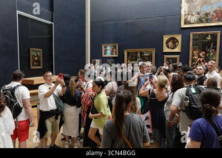 Paris, France - 9 juin 2023 : les touristes se rassemblent pour prendre des photos de la célèbre peinture de la Joconde de Léonard de Vinci à l'intérieur du musée du Louvre. Banque D'Images