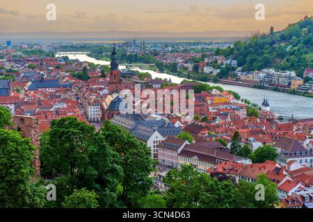 Vue panoramique sur le paysage pittoresque de Heidelberg avec le fleuve Neckar, le vieux pont et l'architecture historique baignée de lumière douce le soir. Banque D'Images