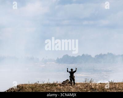 Un soldat d'infanterie polonais des Forces de défense territoriale donne des ordres lors d'un entraînement au tir réel pour une attaque surprise lors de la journée médiatique Iron Defender 25. L’exercice Iron Defender 25 est l’événement d’entraînement le plus important et le plus important planifié par et pour les forces armées polonaises. Il s'agit d'une série d'exercices défensifs menés sur terre, dans les airs et sur l'eau par les forces terrestres, aériennes, navales, spéciales et territoriales de défense. Trente mille soldats et 600 pièces d'équipement des forces armées polonaises et des alliés de l'OTAN y participent. Banque D'Images