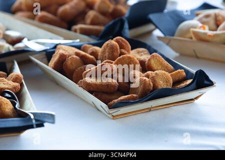 Gros plan d'un plateau de nuggets de poulet assis sur une table à côté d'autres hors-d'œuvre lors d'un événement traiteur Banque D'Images