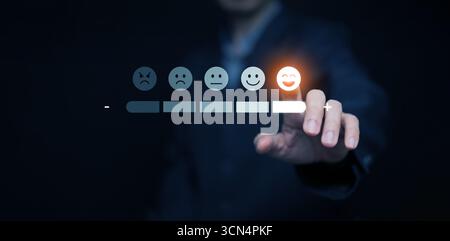 Gros doigt touchant émoji smiley sur la barre d'évaluation numérique, symbolisant la satisfaction du client, sondage en ligne, système de rétroaction, gestion de la réputation, Banque D'Images