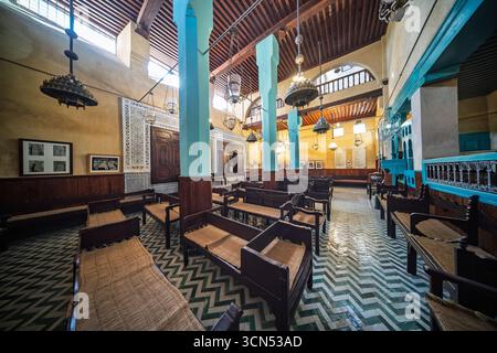 Les visiteurs explorent la synagogue Al Fassiyine à Fès, en réfléchissant sur l'histoire et la culture juives dans un espace magnifiquement restauré du XVIIe siècle. Banque D'Images