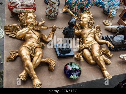 Marché aux puces à Paris, France. Deux bébés anges dorés jouant au violon et à la trompette. Carte postale de nature morte de style rétro. Banque D'Images