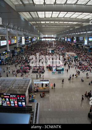 Une photo en grand angle d'un terminal de gare chinois moderne bondé avec un grand nombre de voyageurs en attente et en mouvement. Banque D'Images