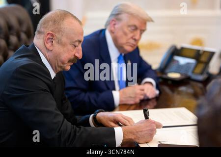 Le président azerbaïdjanais Ilham Aliyev signe la déclaration conjointe trilatérale alors que le président Donald J. Trump regarde lors du sommet historique à la Maison Blanche à Washington, DC, le 8 août 2025. Image reproduite avec l'aimable autorisation de la Maison Blanche. Banque D'Images