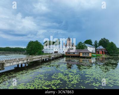 Une vue aérienne à faible angle du monastère de l'île Vvedensky, montrant les bâtiments et les passerelles reliant l'île au littoral verdoyant. Banque D'Images