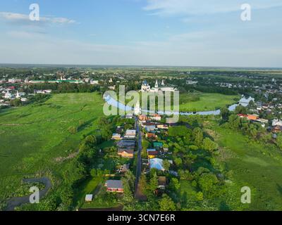 Une large vue aérienne de la ville de Souzdal, montrant la rivière Kamenka serpentant à travers la zone urbaine et les monastères historiques. Banque D'Images