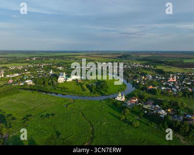 Une large vue aérienne de la ville de Souzdal, montrant la rivière Kamenka serpentant à travers la zone urbaine et les monastères historiques. Banque D'Images