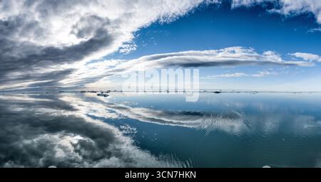 Klerckbukta Nordaustlandet Svalbard glace de mer arctique // NORDEAUSTLANDET, SVALBARD — les icebergs flottent dans la mer arctique calme au large de Nordaustlandet, Svalbard, un vaste archipel de l'océan Arctique. La région est caractérisée par son terrain accidenté et montagneux et ses vastes glaciers, Klerckbukta étant une baie remarquable. Le Svalbard est connu pour ses paysages spectaculaires et sa couverture importante de glace de mer, qui joue un rôle crucial dans l’écosystème arctique. L'environnement unique de la région attire la recherche scientifique et témoigne des changements en cours dans les régions polaires. Banque D'Images