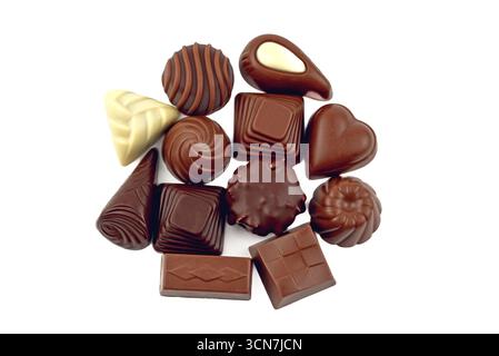 Un bouquet de chocolats assortis sont empilés les uns sur les autres. Les chocolats sont de différentes formes et tailles, et ils sont tous bruns. Concept de in Banque D'Images