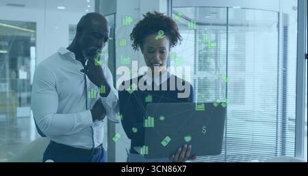 Examen des graphiques financiers verts sur ordinateur portable, professionnels debout par cloison de verre dans le bureau Banque D'Images