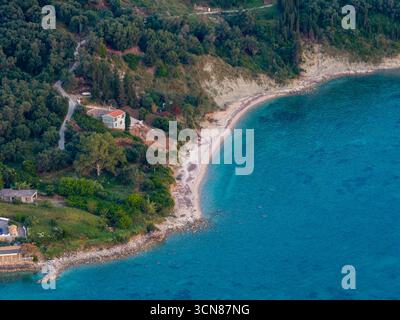 Vue aérienne drone d'une villa isolée avec une plage privée sur la magnifique côte turquoise de Corfou, Grèce. Une escapade paradisiaque cachée nichée dans le Banque D'Images