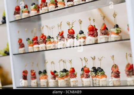 Élégants hors-d'œuvre gastronomique sur brochettes servis lors d'une réception de mariage ou de banquet de luxe Banque D'Images
