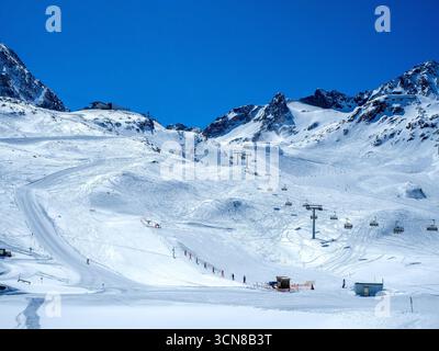 Glacier de Stubai dans les Alpes autrichiennes avec pistes de ski, télésièges, télésiège, téléphérique, skieurs et snowboarders. Ciel bleu avec espace de copie Banque D'Images