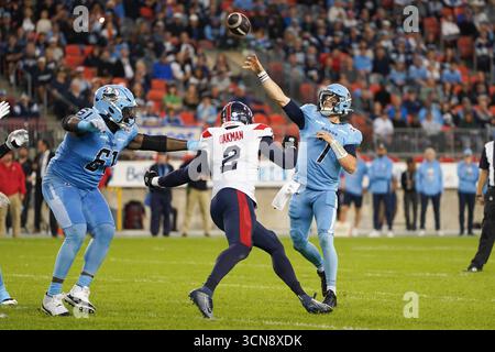 Toronto, Canada. 19 septembre 2025. Le quarterback Jarret Doege #7 des Argonauts de Toronto lance une passe sous la pression de la ligne défensive Shawn Oakman #2 des Alouettes de Montréal en première mi-temps lors du match de football de la semaine 16 de la LCF 2025 au BMO Field. Le 19 septembre 2025 à Toronto, Canada. (Photo de Leonardo Ramirez/Eyepix Group/Sipa USA) crédit : Sipa USA/Alamy Live News Banque D'Images