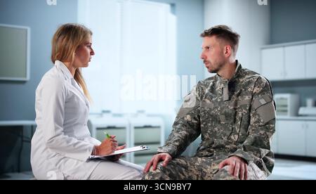 Jeune femme médecin militaire fournit une thérapie de santé mentale à Un soldat. Banque D'Images