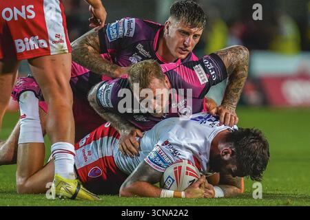 ST HLENES, ANGLETERRE - 19 septembre : Alex Mellor et Joe Westerman de Castleford Tigers font le tacle sur Kyle Feldt de St Helens. Match de Betfred Super League entre St Helens et Castleford Tigers au Totally Wicked Stadium le 19 septembre 2025 à St Helens en Angleterre. (Photo de James Giblin) Banque D'Images