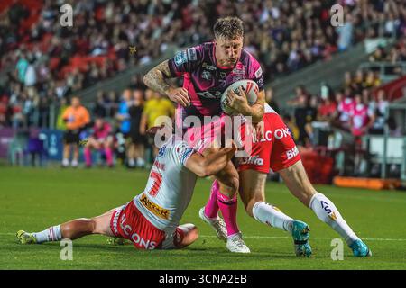 ST HLENES, ANGLETERRE - 19 septembre : Alex Mellor de Castleford Tigers est chargé par deux Saints Defenders. Match de Betfred Super League entre St Helens et Castleford Tigers au Totally Wicked Stadium le 19 septembre 2025 à St Helens en Angleterre. (Photo de James Giblin) Banque D'Images