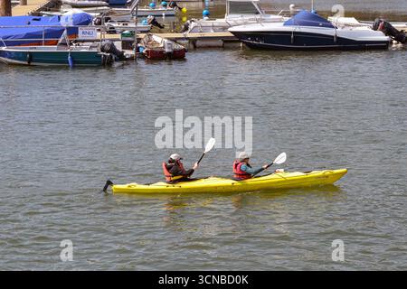 Dartmouth, Devon, Angleterre, Royaume-Uni - 24 avril 2025 : deux personnes faisant du kayak sur la rivière Dart Banque D'Images