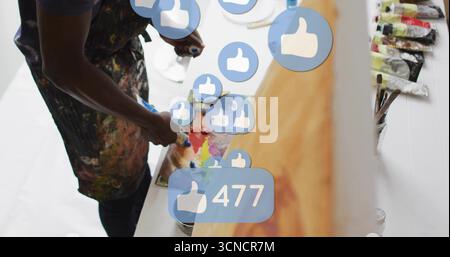 Mélange peintre mélange de couleurs sur palette en studio, icônes pouce vers le haut, espace de copie Banque D'Images