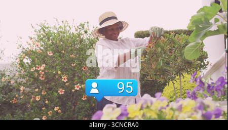Jardinier taillant portant chapeau de paille, gants dans le jardin avec sécateurs et icône de notification 95 Banque D'Images