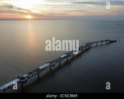 Photo aérienne de la jetée à Międzyzdroje, Pologne. Prise au coucher du soleil avec mer, soleil et plage. Banque D'Images