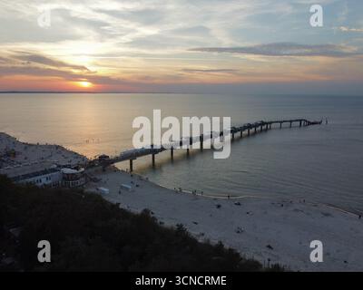 Photo aérienne de la jetée à Międzyzdroje, Pologne. Prise au coucher du soleil avec mer, soleil et plage. Banque D'Images