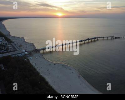 Photo aérienne de la jetée à Międzyzdroje, Pologne. Prise au coucher du soleil avec mer, soleil et plage. Banque D'Images