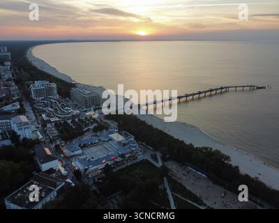 Photo aérienne de la jetée à Międzyzdroje, Pologne. Prise au coucher du soleil avec mer, soleil et plage. Banque D'Images