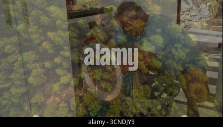 Agenouillement homme senior chargeant les vêtements dans la laveuse à chargement frontal dans la buanderie, avec panier tissé Banque D'Images