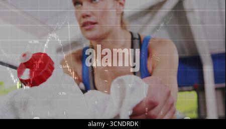 Poignée de rameur enveloppée d'une serviette avec bouton rouge femme portant un haut d'entraînement bleu dans la salle de gym Banque D'Images