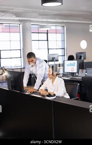 Divers collègues se penchant sur le bureau et collaborant sur des écrans de bureau au bureau Banque D'Images