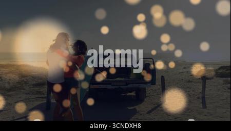 Couple embrassant regardant le coucher du soleil sur le rivage de sable, avec pick-up et planche de surf, espace copie Banque D'Images