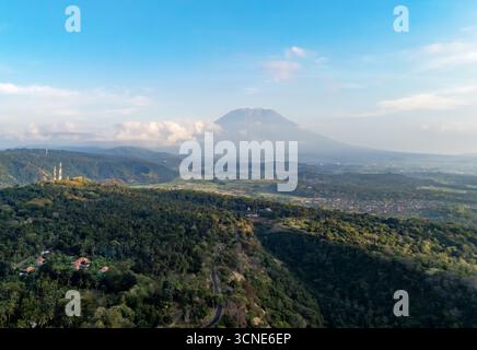 Vue aérienne du lever du soleil de kintamani, Bali, Indonésie, vallées brumeuses, terres agricoles vertes, et majestueux mont Batur, mont Agung Banque D'Images