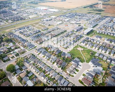 Vue aérienne de Kensington à Saskatoon, Saskatchewan, montrant de nouvelles maisons résidentielles, des étangs pluviaux et des parcs communautaires. Banque D'Images