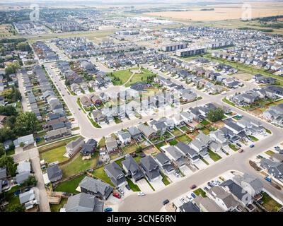 Vue aérienne de Kensington à Saskatoon, Saskatchewan, montrant de nouvelles maisons résidentielles, des étangs pluviaux et des parcs communautaires. Banque D'Images