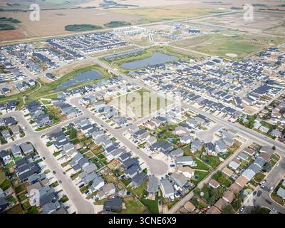 Vue aérienne de Kensington à Saskatoon, Saskatchewan, montrant de nouvelles maisons résidentielles, des étangs pluviaux et des parcs communautaires. Banque D'Images