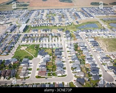 Vue aérienne de Kensington à Saskatoon, Saskatchewan, montrant de nouvelles maisons résidentielles, des étangs pluviaux et des parcs communautaires. Banque D'Images